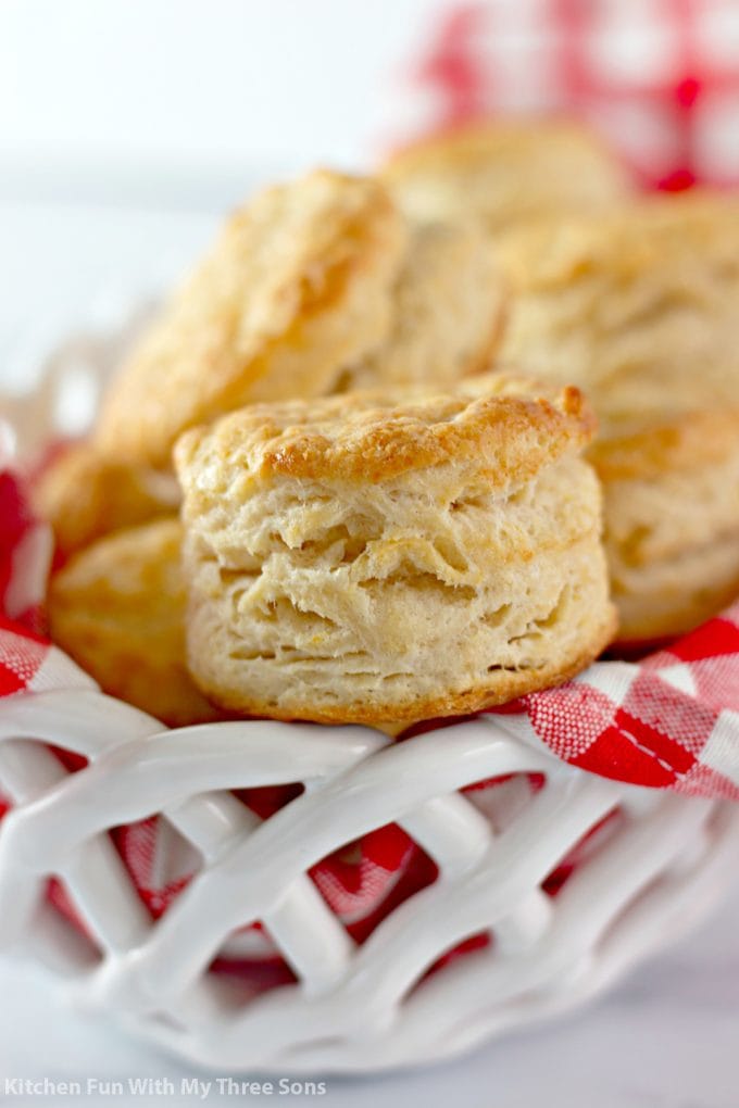 Honey Butter Biscuits in a white basket with a red checkered napkin