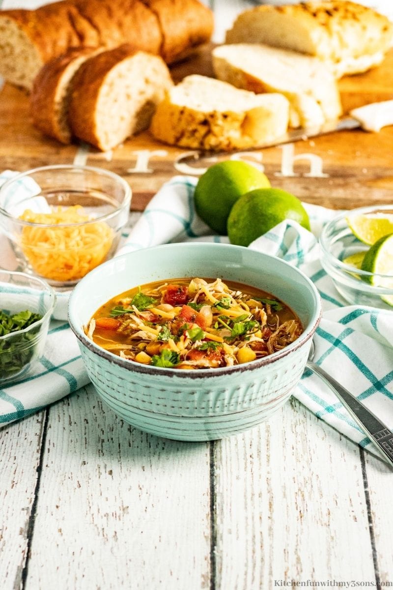 Instant Pot Chili Lime Chicken Soup Recipe with a loaf of bread sliced behind it.