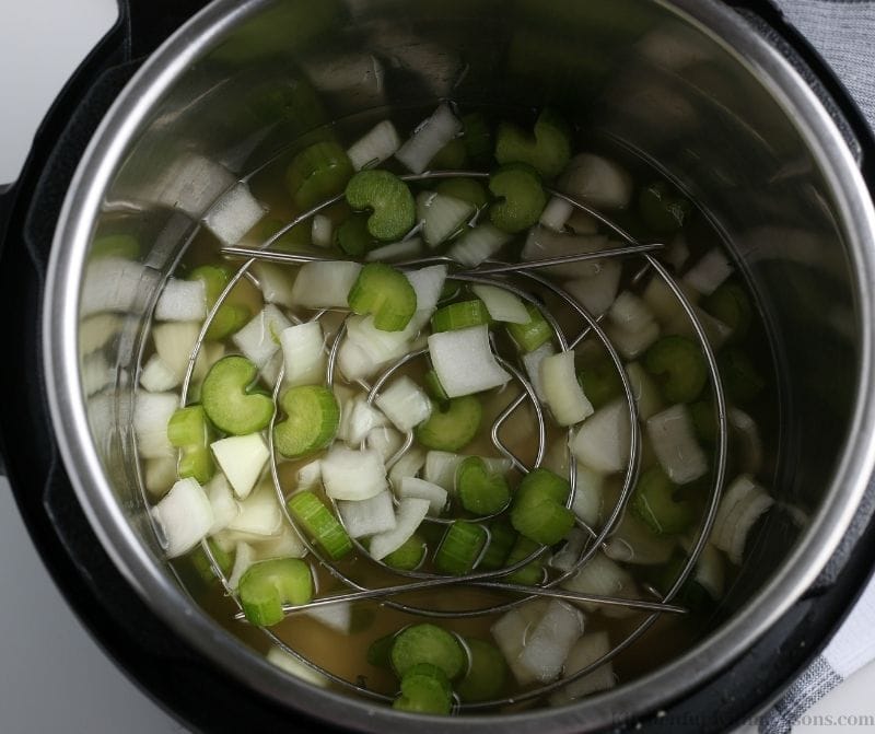 Your prepared and chopped vegetables in the broth in the Instant Pot.