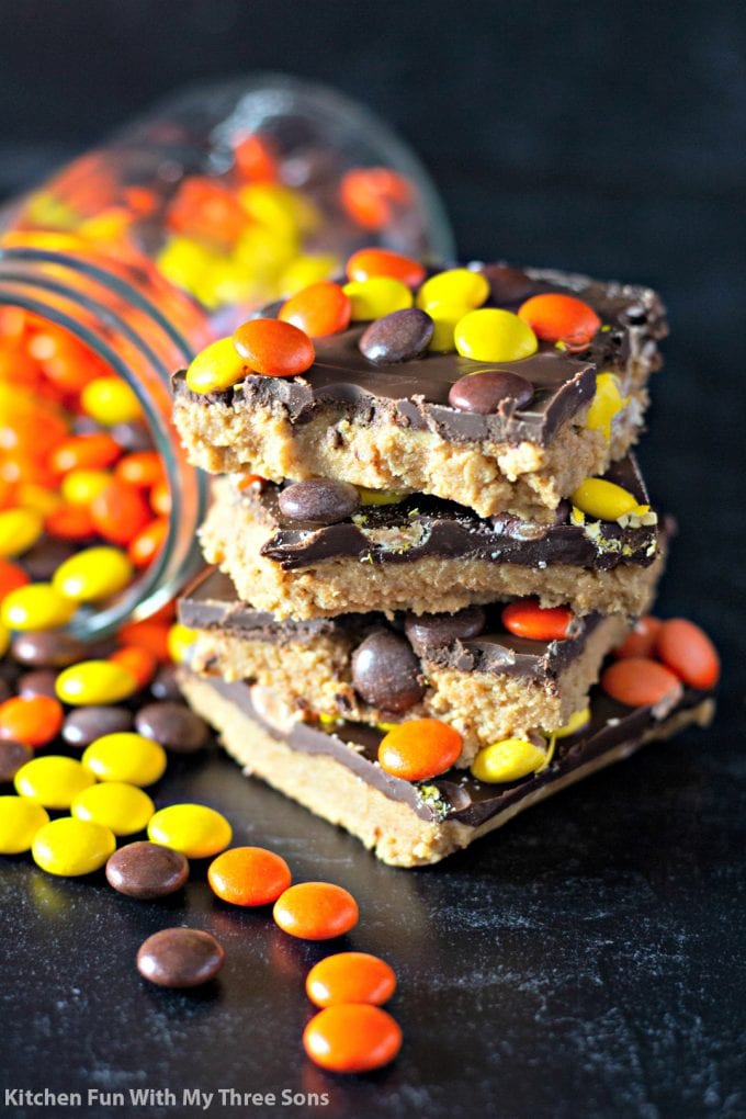 No Bake Reese's Peanut Butter Bars next to a jar of Reese's Pieces
