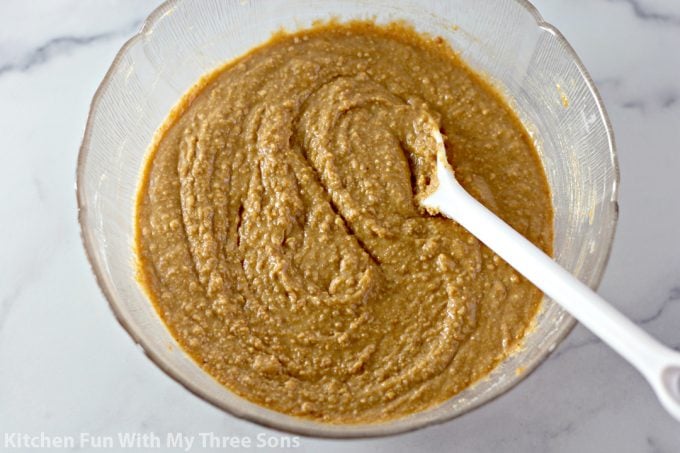 peanut butter mixture in a clear bowl with a white spoon