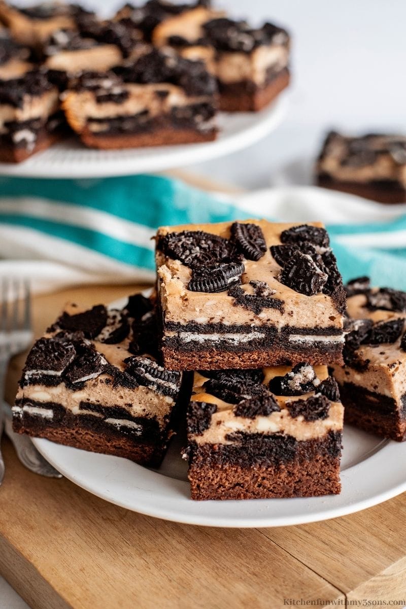 Oreo Brownie Cheesecake Bars stacked on top of each other.