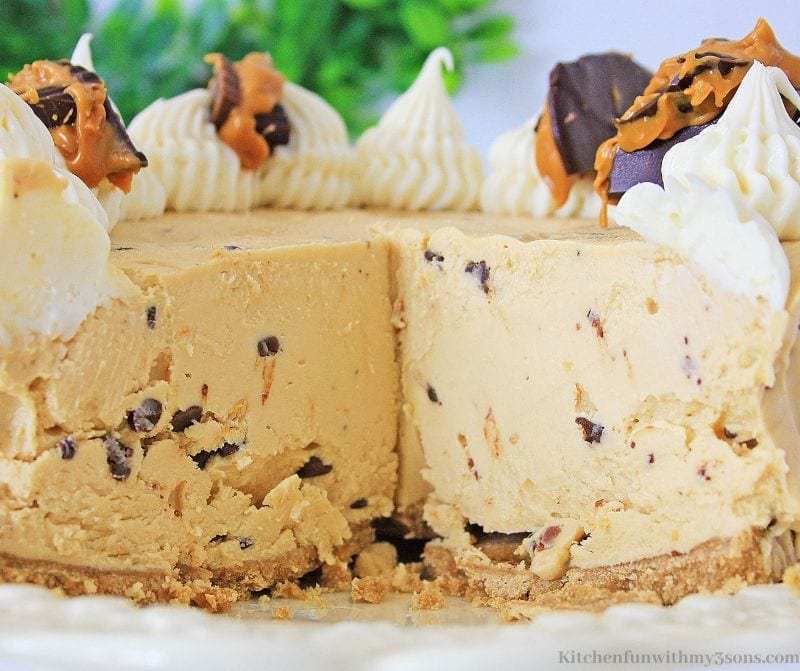 The whole Peanut Butter Chocolate Chip Cheesecake with a slice cut out of it.