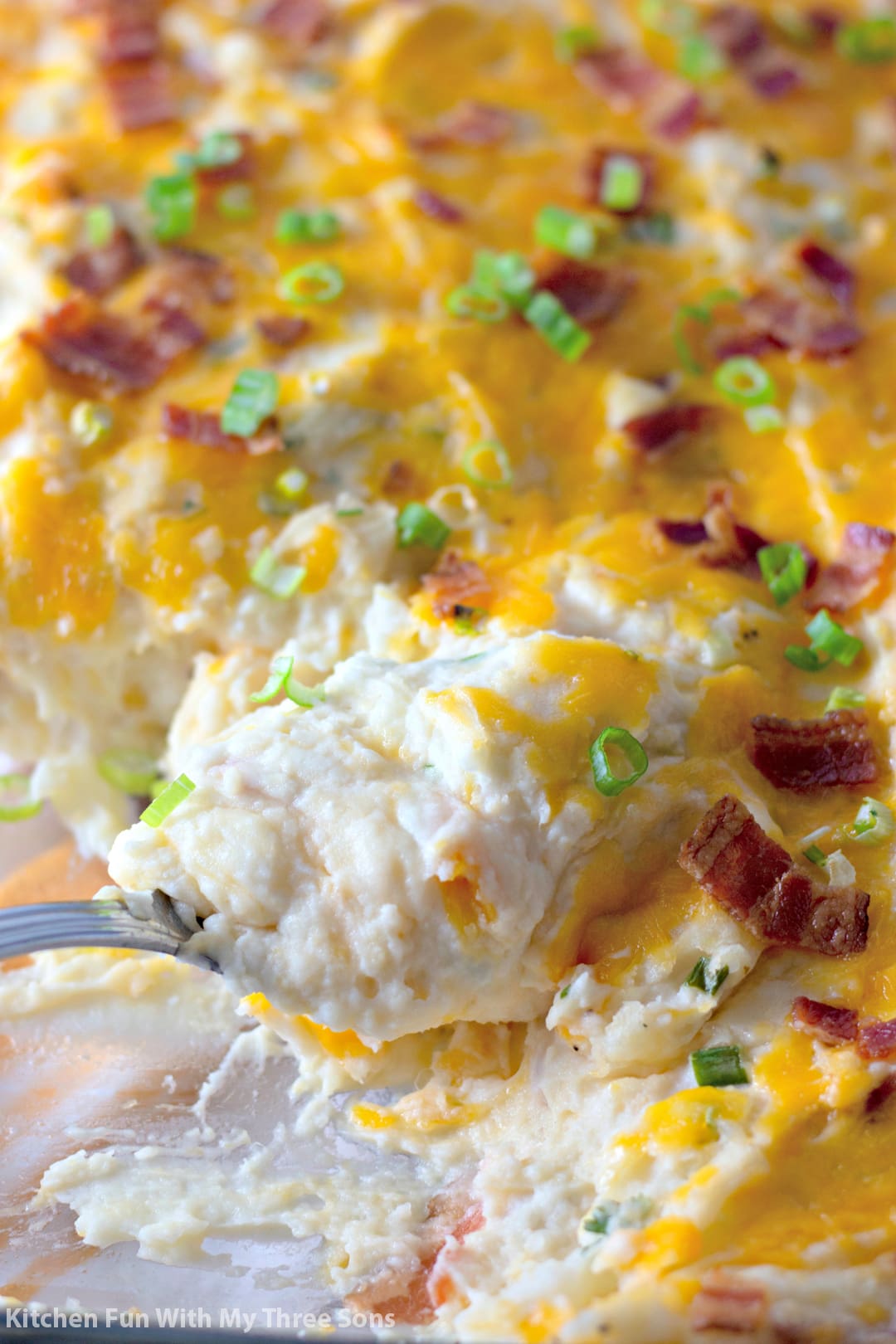 scooping Twice Baked Potato Casserole with a serving spoon