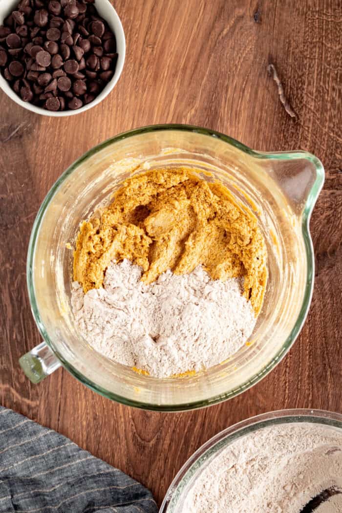 These Pumpkin Chocolate Chip Bars are soft, moist, and packed with cozy Fall flavor and melty chocolate chips! adding the flour into the batter in a bowl
