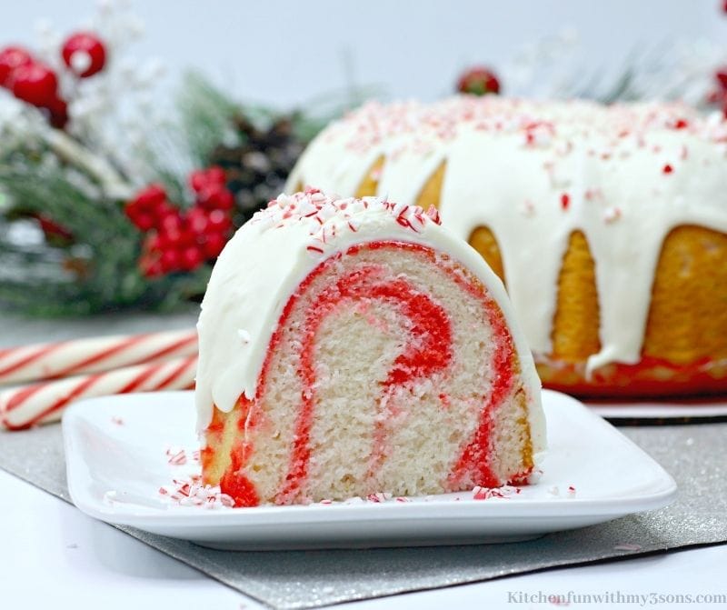 Candy Cane Bundt Cake with candy canes and branches behind it.
