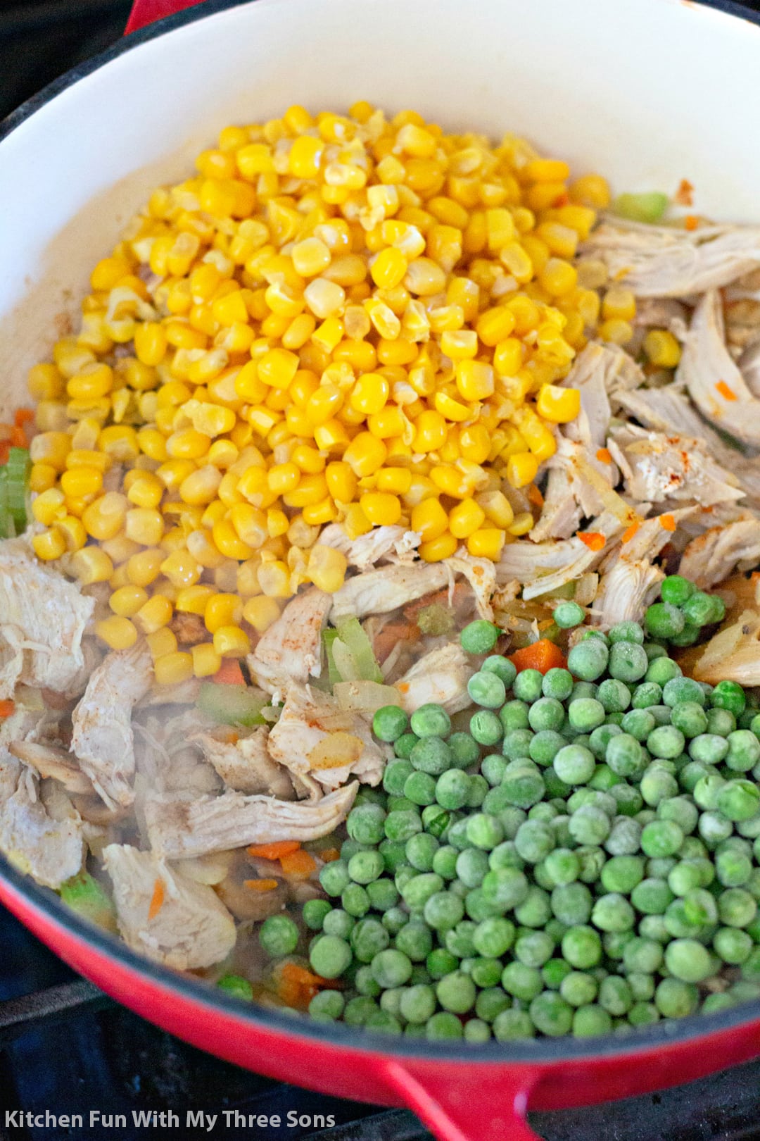 Sweet corn, peas, and chicken are added into the sauteed veggies for Chicken Pot Pie Soup.
