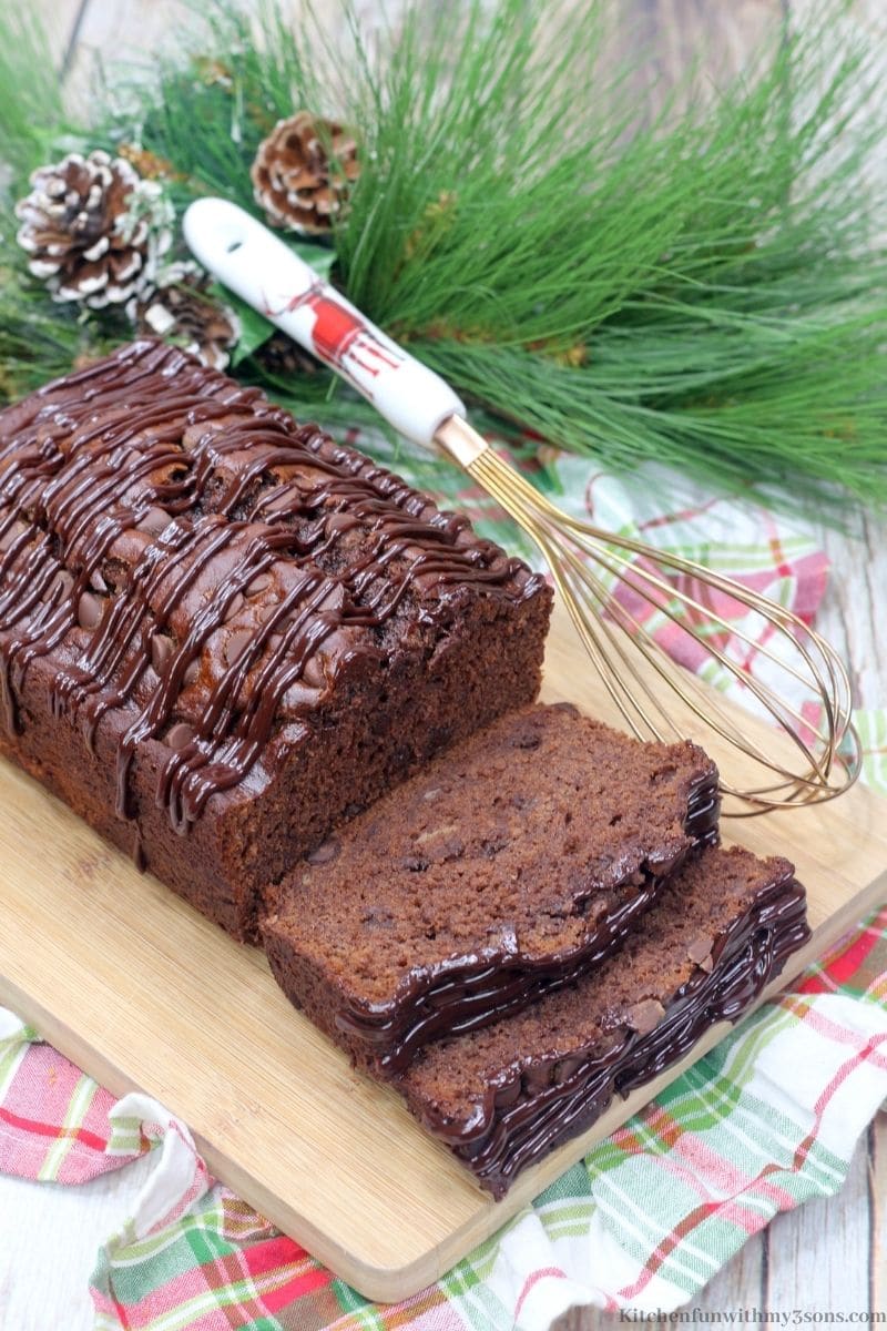 Chocolate Espresso Banana Bread on a patterned cloth and decorations next to it.