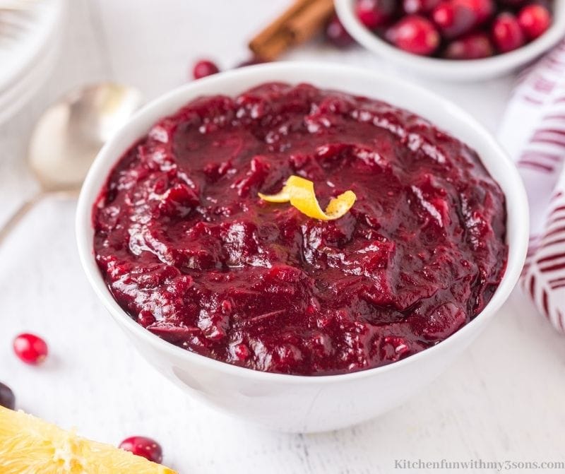 Cinnamon Spice Cranberry Sauce in a bowl topped with a lemon zest.