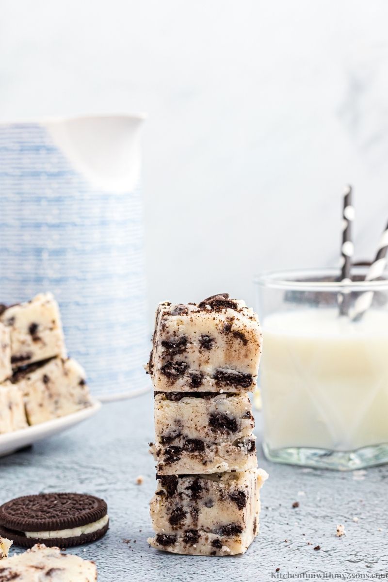 Cookies and Cream Fudge with milk and Oreos behind it.