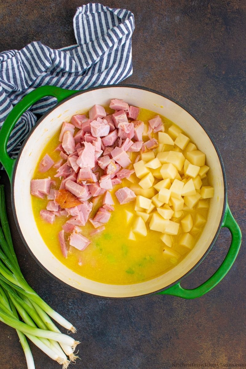 Adding the ham and potatoes into the broth.