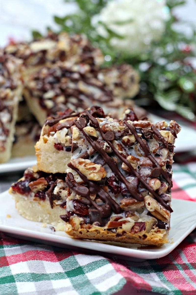 Dark Chocolate Cranberry Magic Bars with leafed decorations in the back.
