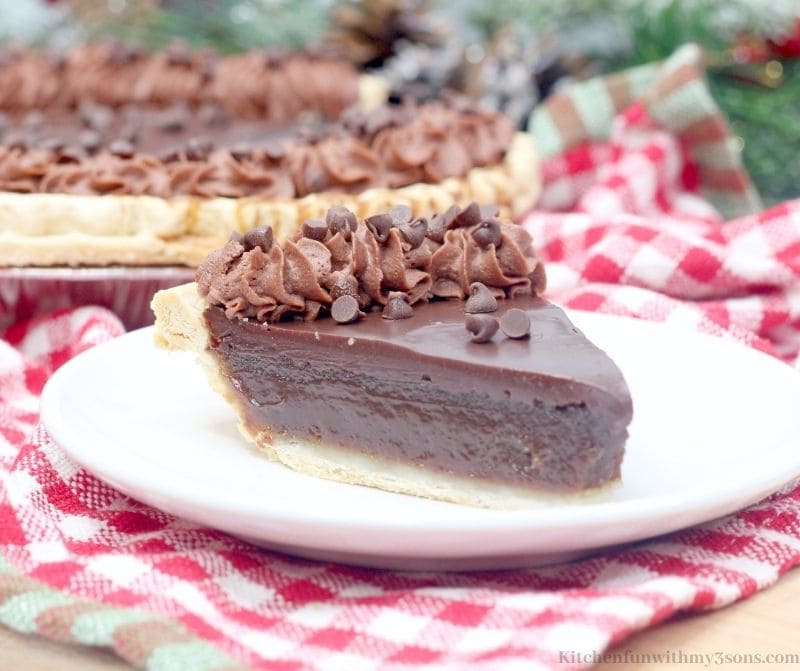 Decadent Chocolate Buttermilk Pie slice with the rest of the pie behind it.