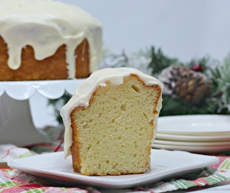 A slice of the Eggnog Cake with the rest of the cake behind it.