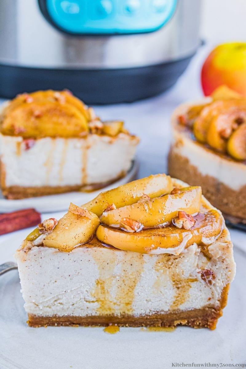Instant Pot Apple Cinnamon Cheesecake with more slices on serving plates behind it.