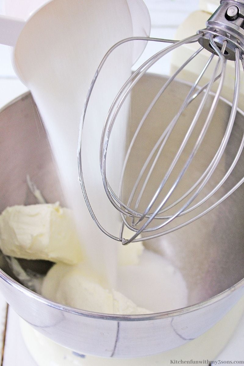 Mixing the cream cheese and the sugar in a stand mixer.