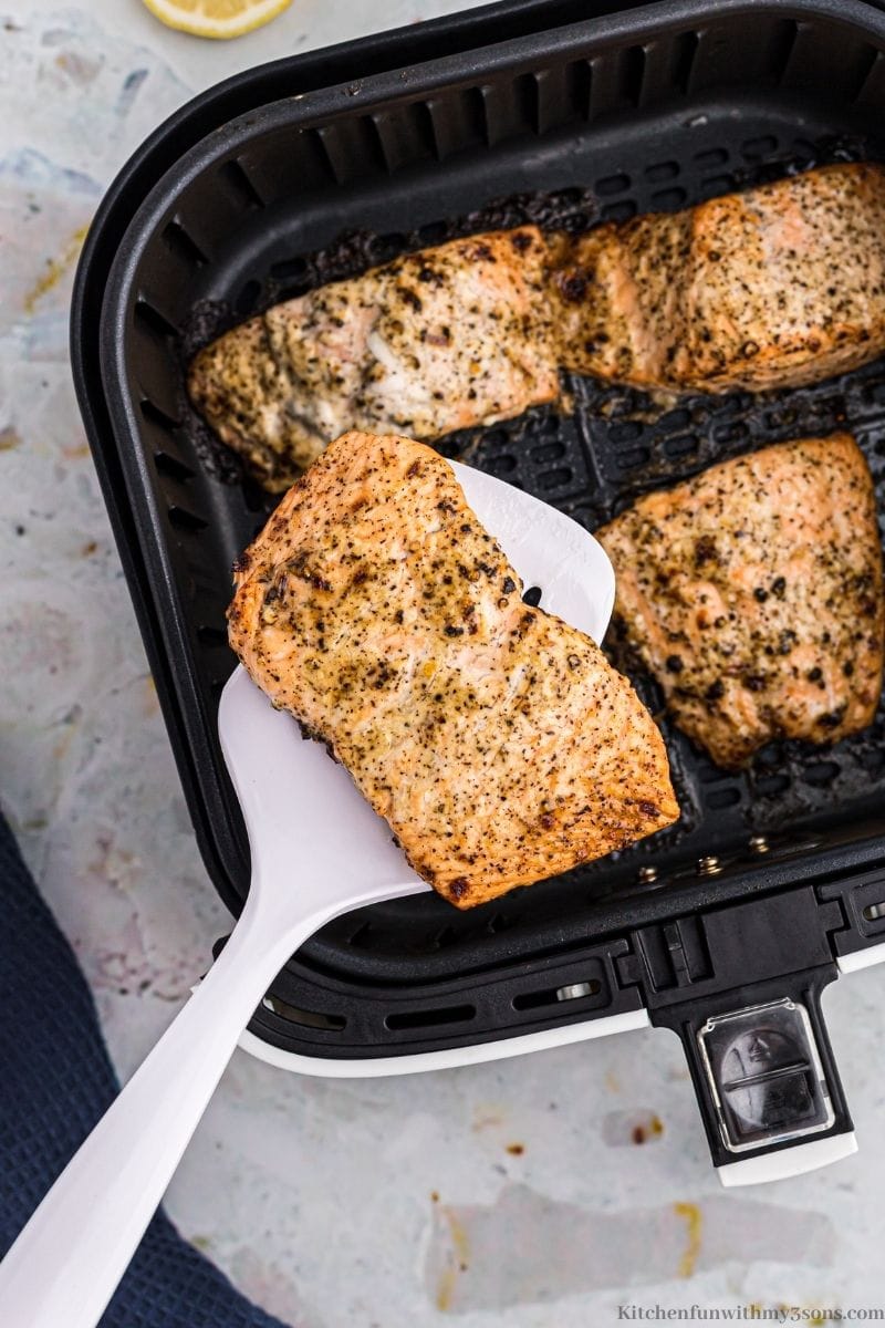 Salmon in the air fryer, one being lifted out by a spatula