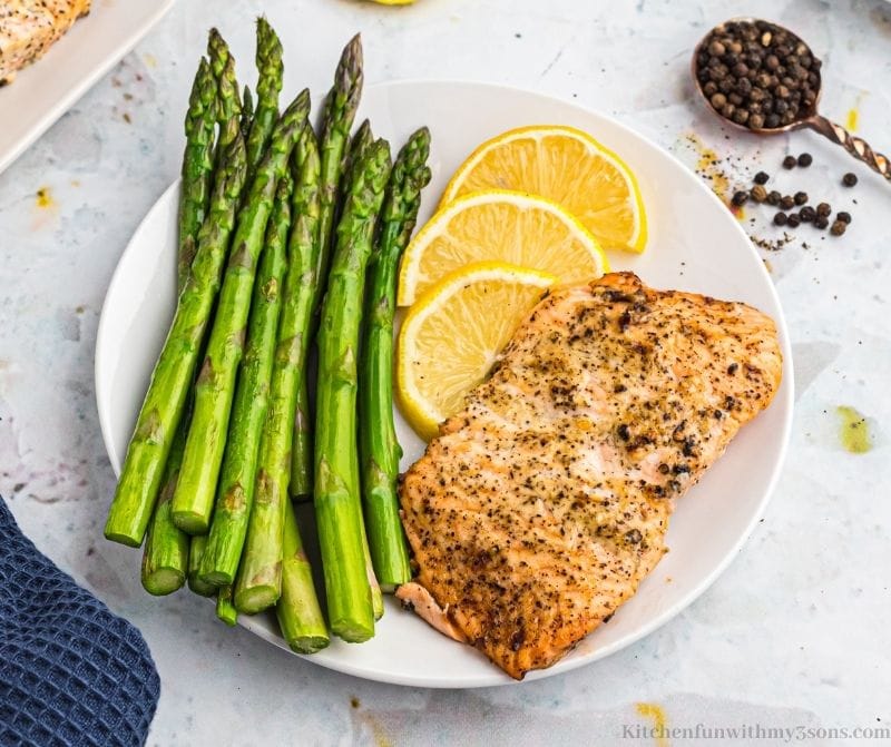 Lemon Pepper Air Fryer Salmon on a serving plate with a side of asparagus.