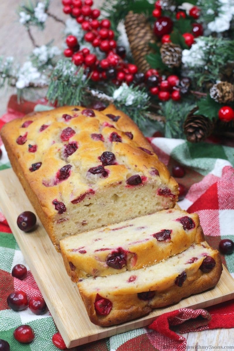 Orange Cranberry Bread with snow frosted decorations behind it.