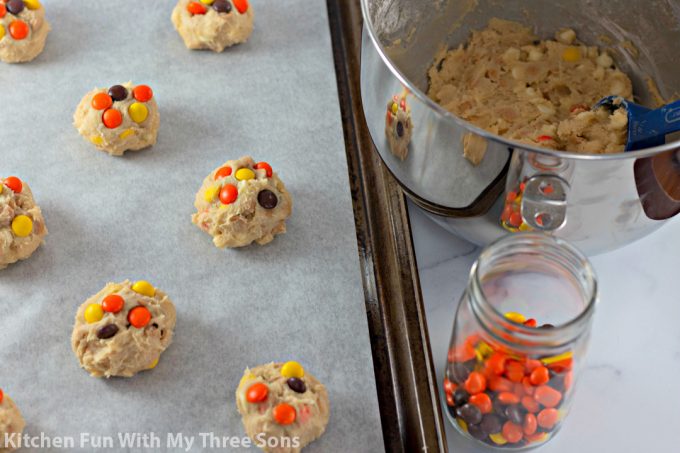 pressing Reese's Pieces onto the cookie dough balls