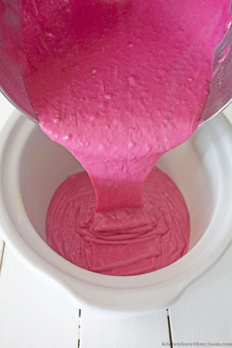 Raspberry batter being poured into the prepared pot.