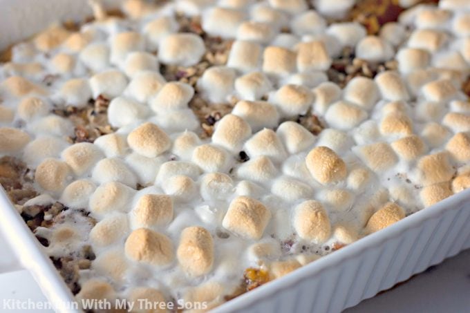a white casserole dish filled with Sweet Potato Casserole with Pecan Streusel and Marshmallows