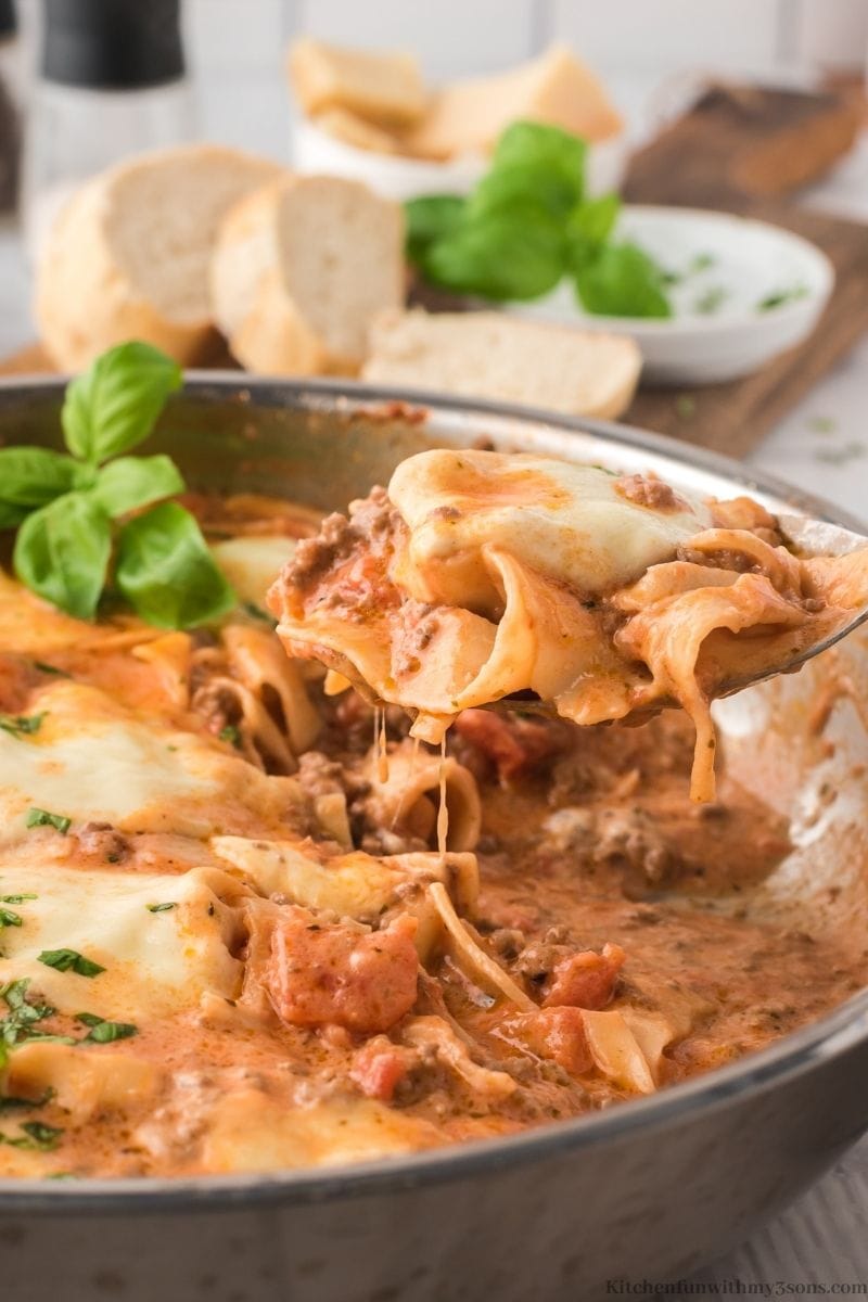A spoon lifting up some of the The Easiest Skillet Lasagna Recipe out of the pan.