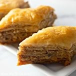 Golden-brown pieces of baklava, served on a small white tray.