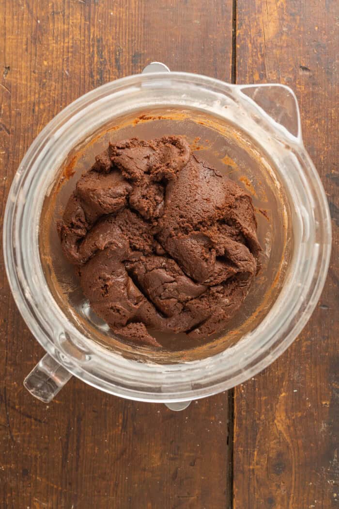 These Chocolate Peppermint Cookies are loaded with semi-sweet, white, and dark chocolate plus crushed peppermint. Soft & chewy! Chocolate cookie dough in a bowl