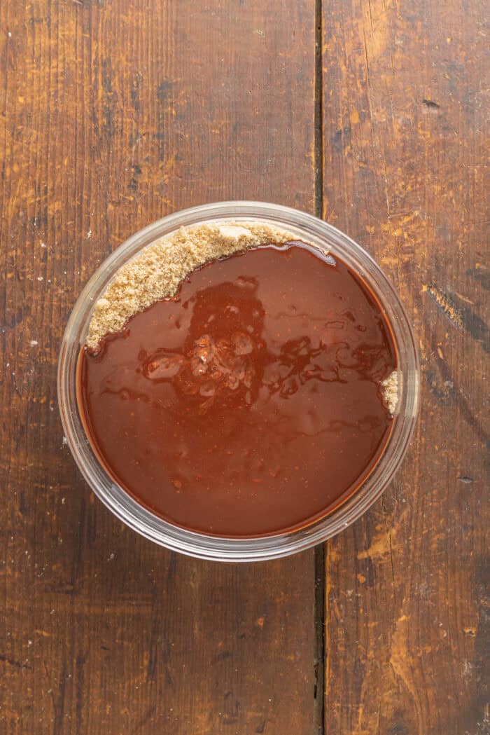 These Chocolate Peppermint Cookies are loaded with semi-sweet, white, and dark chocolate plus crushed peppermint. Soft & chewy! Melted chocolate added to sugars in a bowl