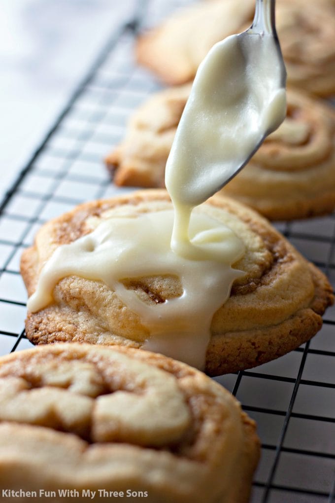 Drizzling frosting onto Frosted Cinnamon Roll Cookies