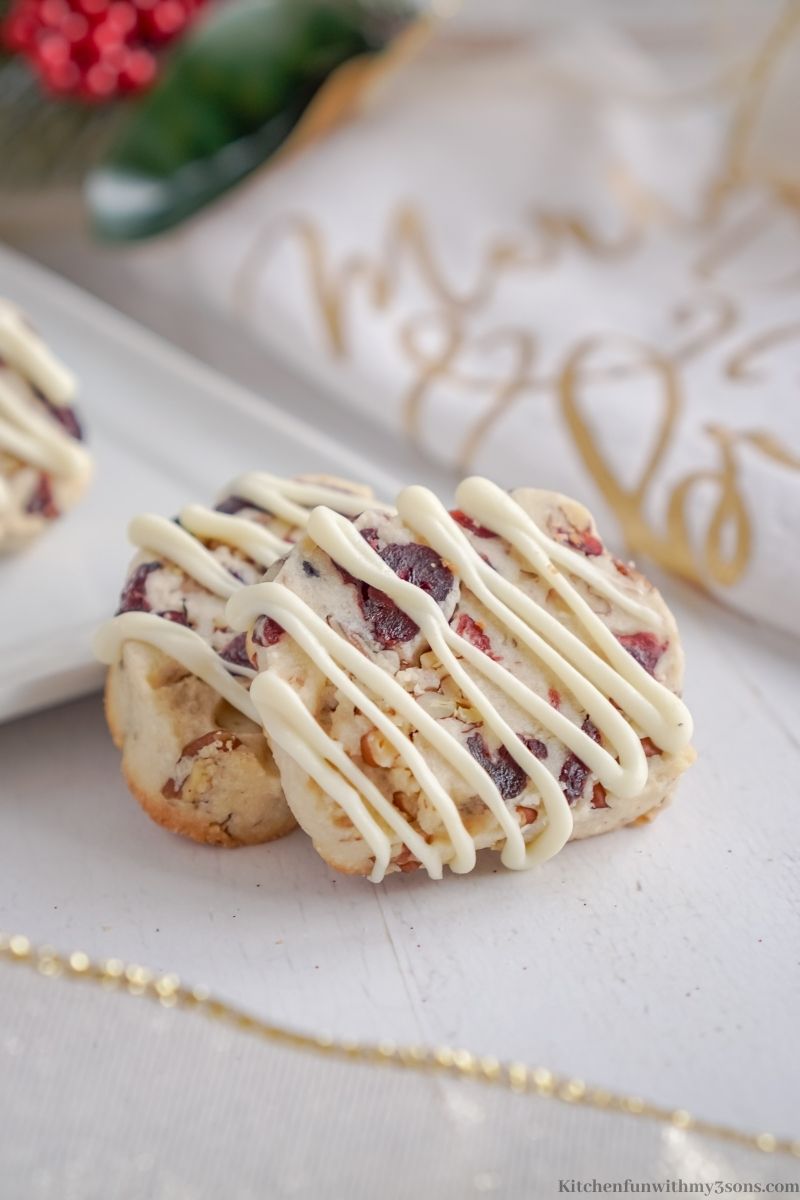 Cranberry Shortbread Cookies on a serving platter with two cookies placed in front.