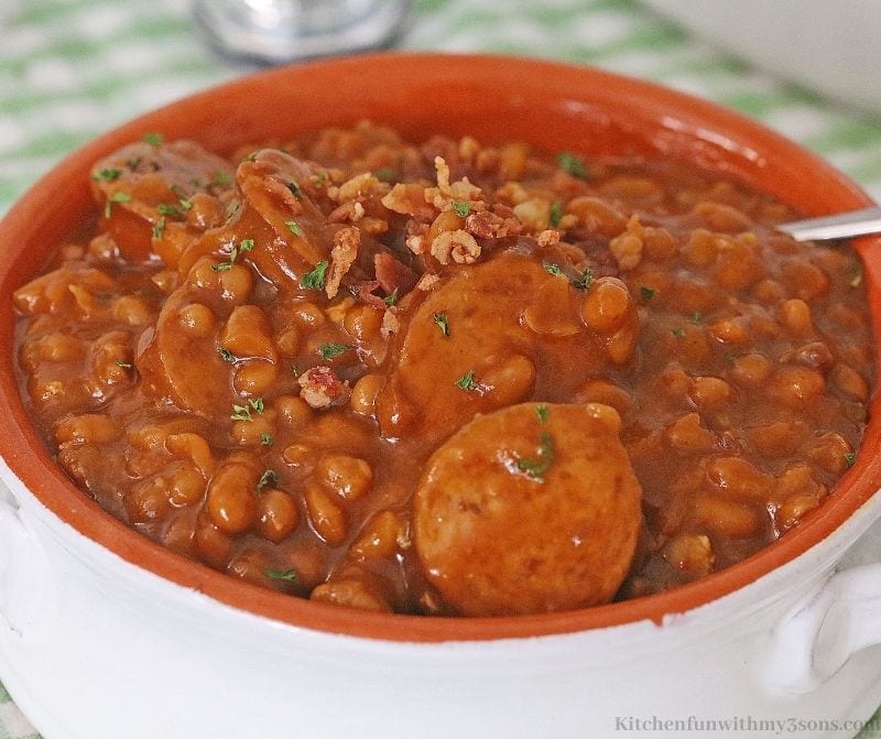 Crock-Pot Kielbasa Sausage and Beans Recipe topped with bacon.