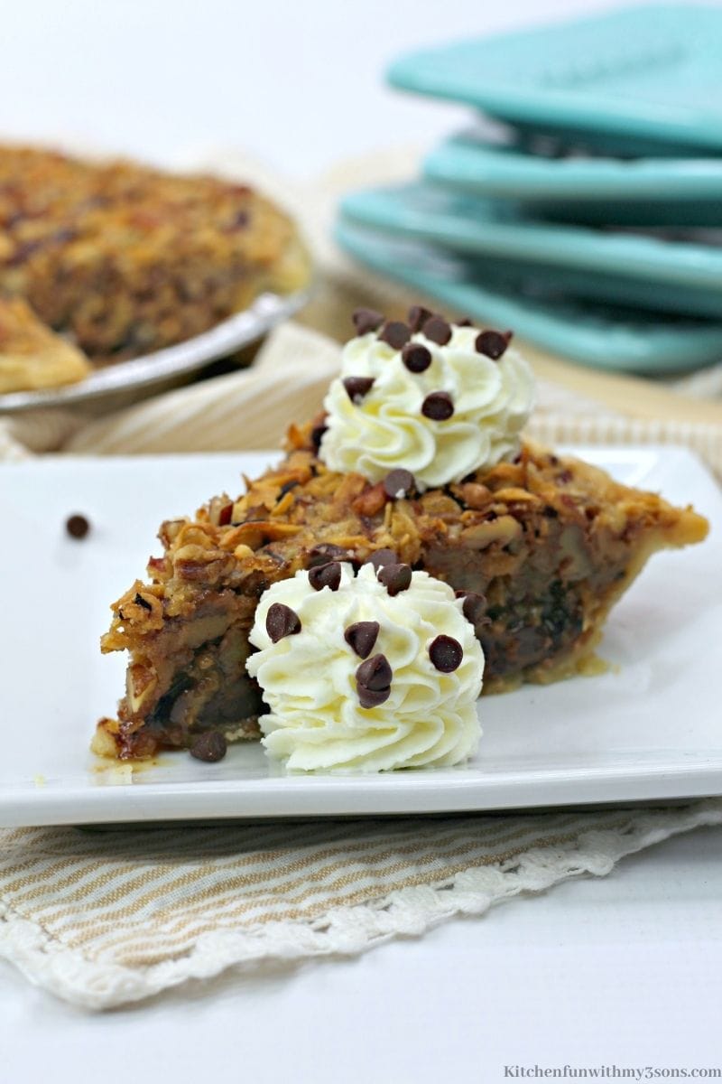 German Chocolate Pecan Pie with two dollops of cream.