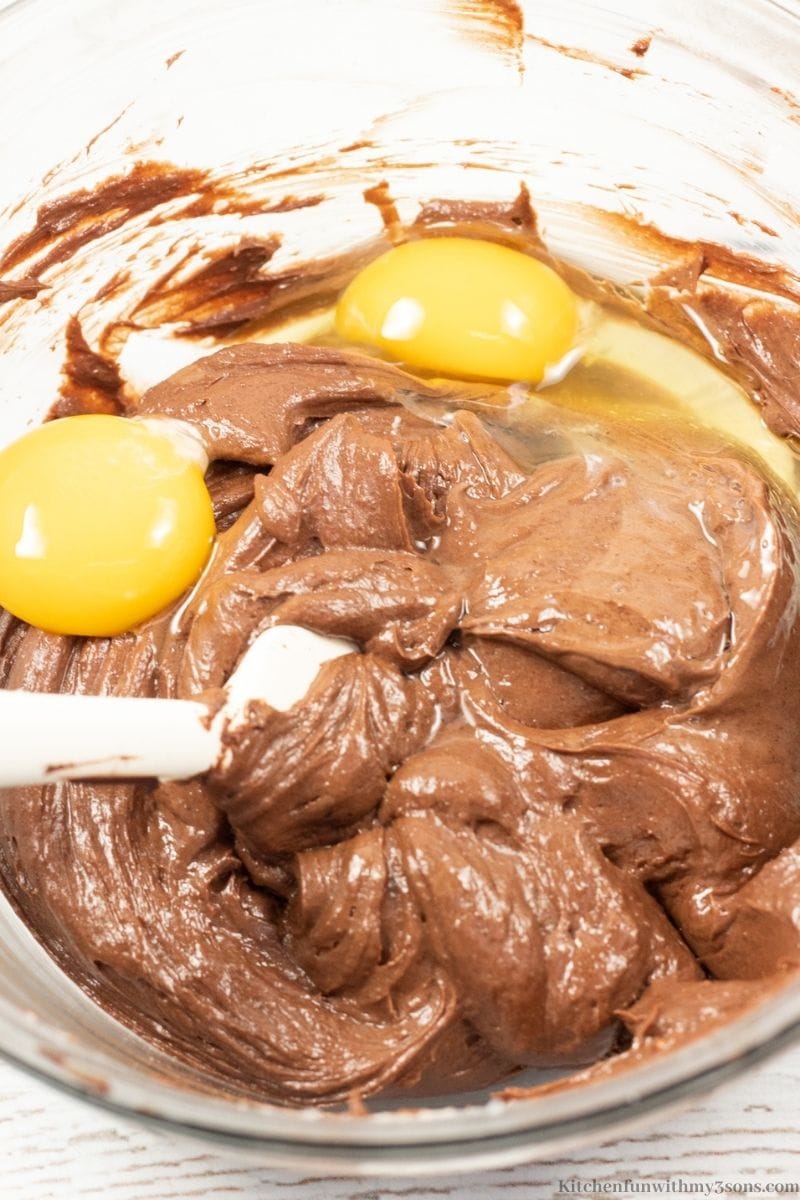 Mixing egg and yolk into the chocolate mixture.