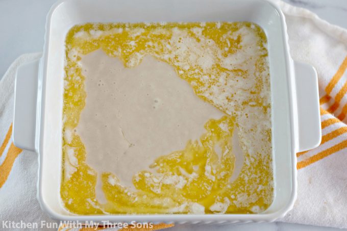 cobbler batter poured over the melted butter in the casserole dish