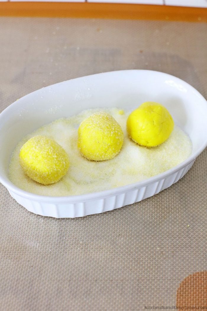 Rolling lemon cookie dough in granulated sugar