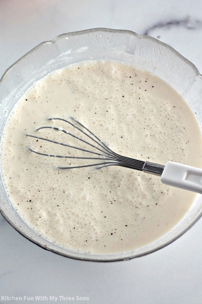 whisking together cream in a mixing bowl