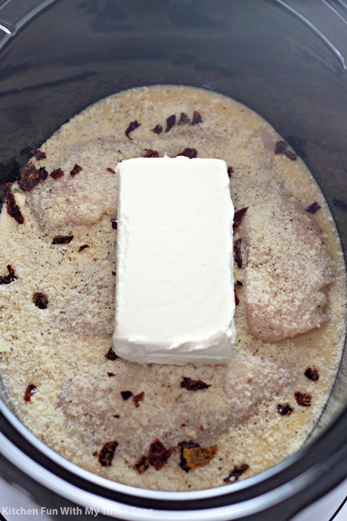 placing a brick of cream cheese in the slow cooker