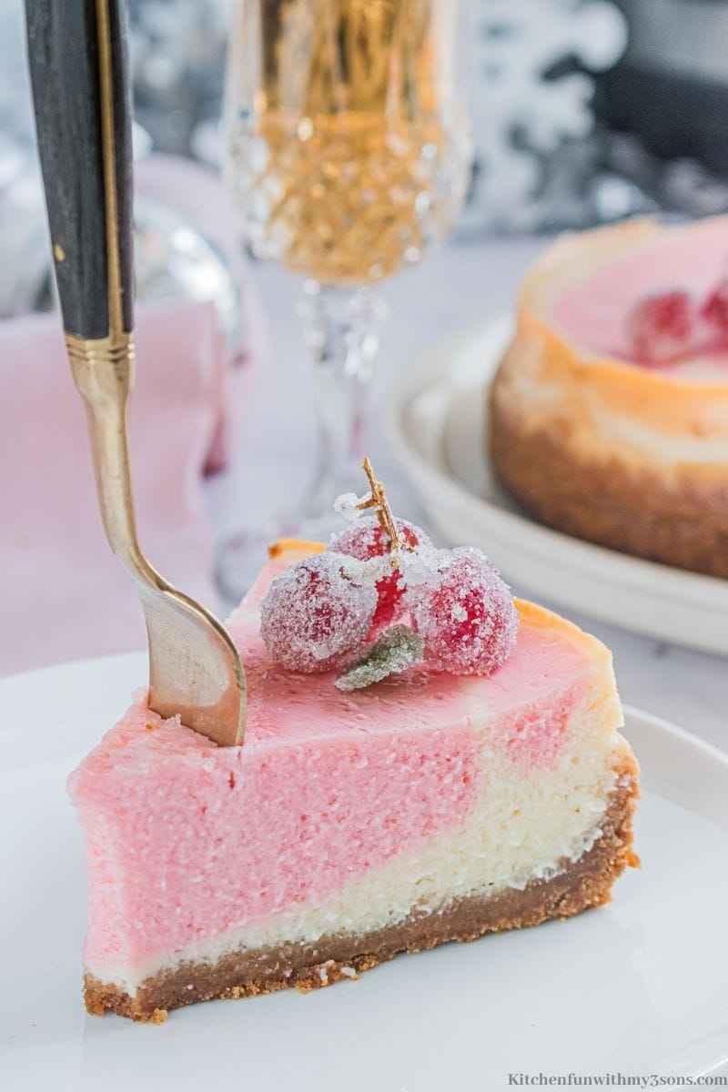 A fork stabbed into a slice of the cheesecake.