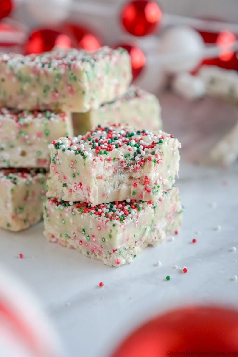 Christmas Cookie Fudge with a bite taken out of one stacked onto another.