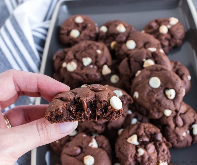 A hand lifting up one of the Triple Chocolate Cookies.