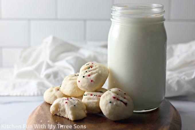 Whipped Shortbread Cookies on a wood tray with milk