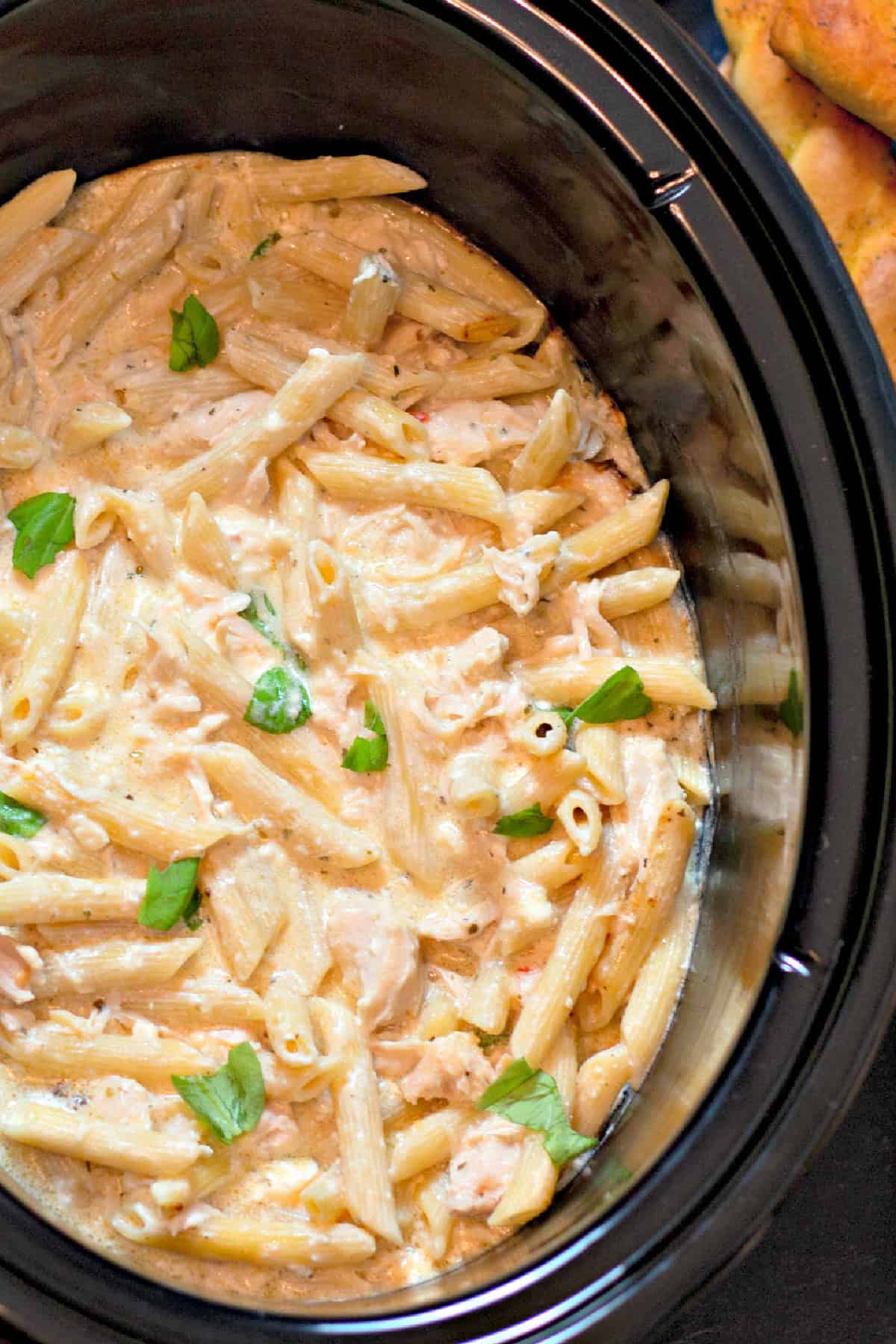This Olive Garden Chicken Pasta is one of the easiest slow cooker dinners you'll ever make! Close up top view of Olive Garden chicken pasta in the slow cooker