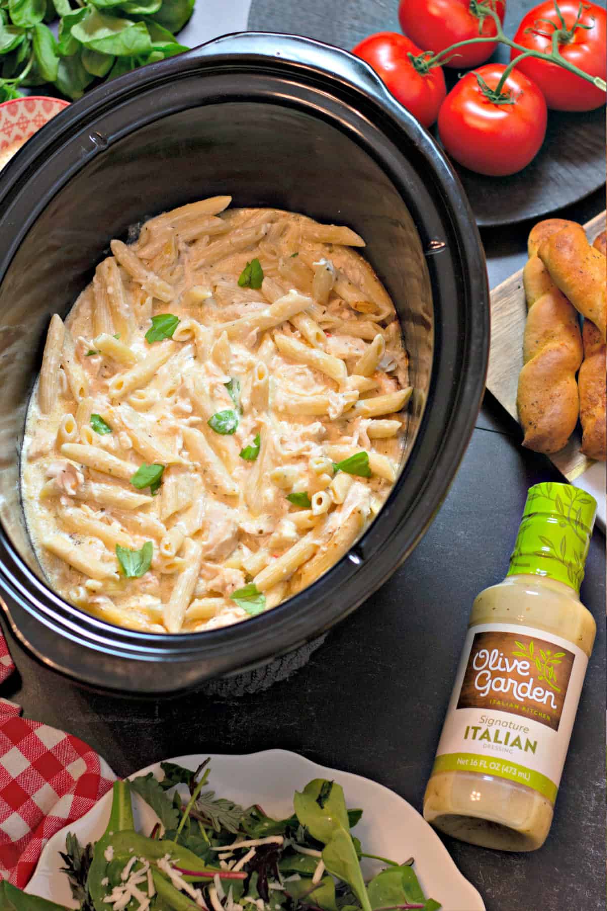 This Olive Garden Chicken Pasta is one of the easiest slow cooker dinners you'll ever make! Olive Garden Chicken Pasta in a slow cooker with sides.