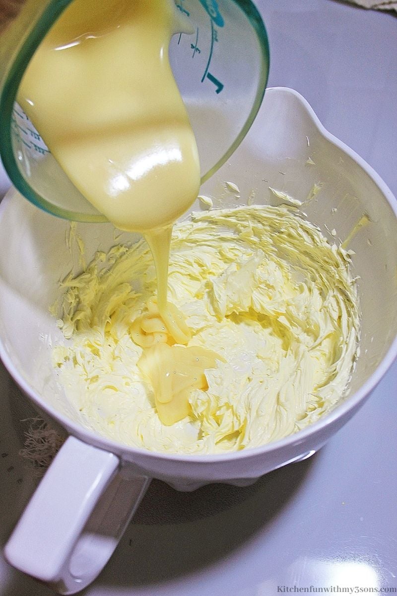 Adding the condensed milk into the frosting.