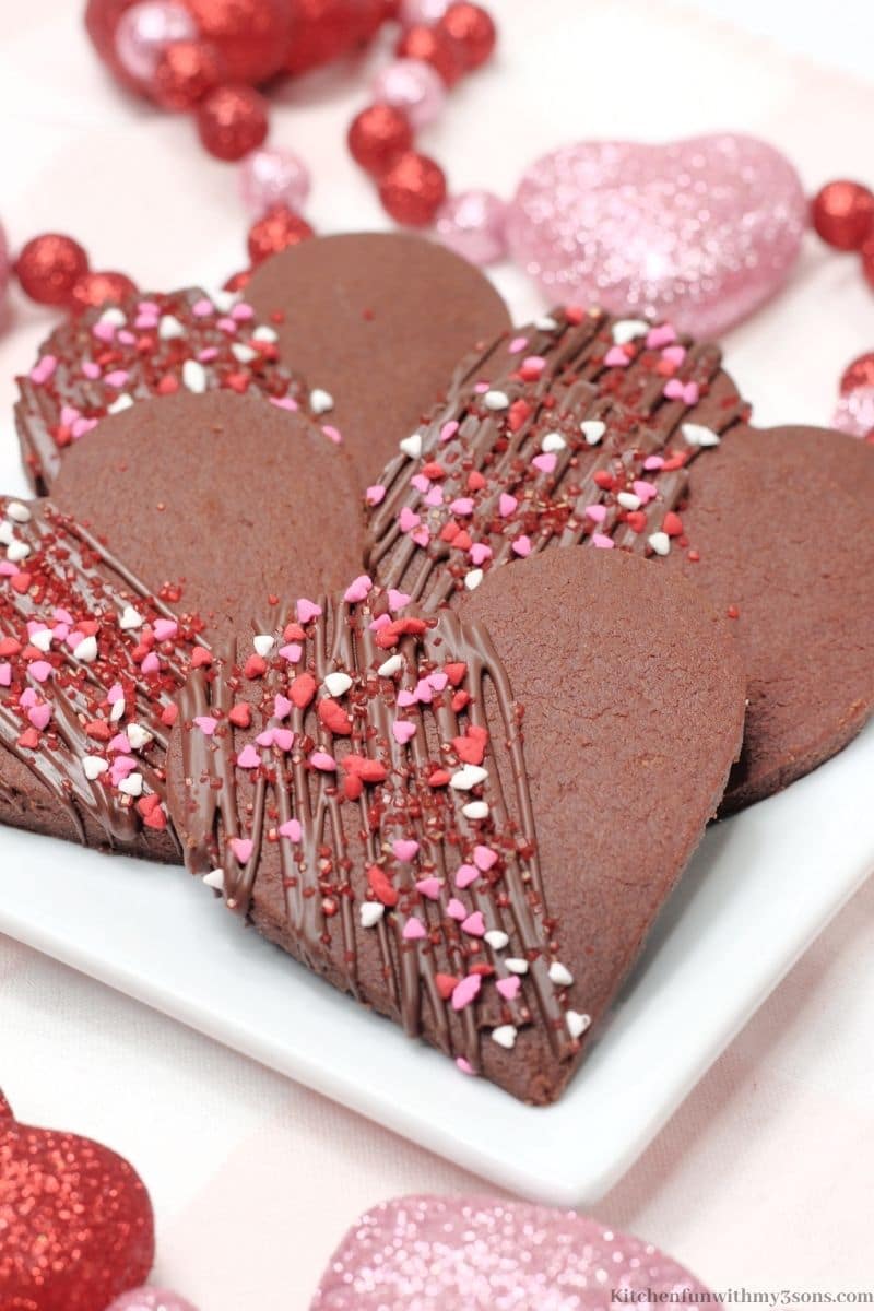 Chocolate Heart Shortbread Cookies with sparkling heart decorations around them.