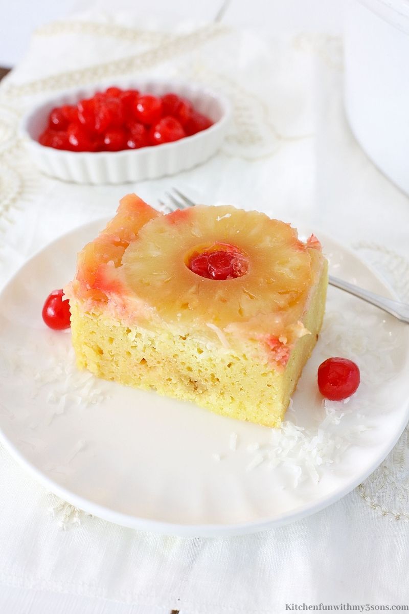 Crock-Pot Pineapple Upside Down Cake with a fork and extra cherries on the side.