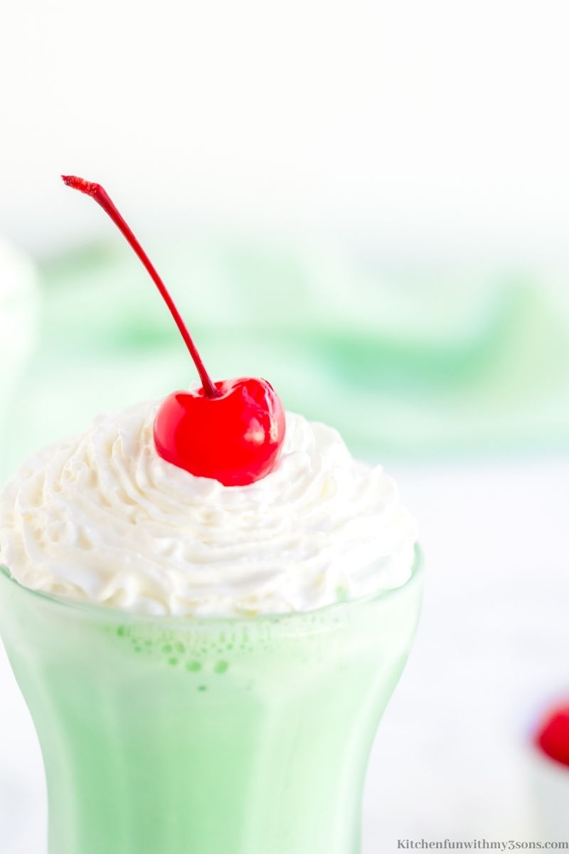 Homemade Shamrock Shake topped with whipped cream and a cherry.