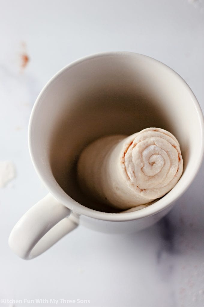 placing the rolled dough into a coffee mug